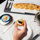 Hand picking up a bilni with caviar on top